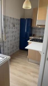 a kitchen with a blue refrigerator and wooden floors at Alessandro home in Rozzano