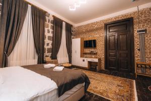 a bedroom with a large bed and a brick wall at Kremlin 1908 Hotel in Kars +22 photos