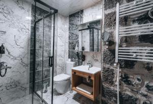 a bathroom with a shower and a toilet and a sink at Kremlin 1908 Hotel in Kars
