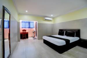 a bedroom with a black and white bed and a desk at Hotel O Meera in Chennai