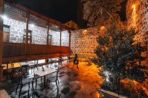 a restaurant with tables and chairs and a brick wall at Kremlin 1908 Hotel in Kars