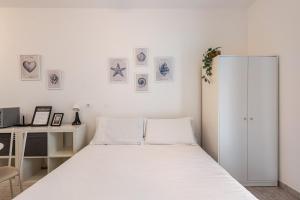a white bedroom with a bed and a desk at Beachfront Studio Free Parking-Pool 50m from Sea in Chioggia +14 photos
