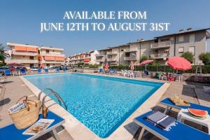 a swimming pool at a resort with a sign that reads available from june at Beachfront Studio Free Parking-Pool 50m from Sea in Chioggia