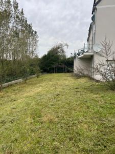 a grassy yard in front of a building at Grande Villa de Prestige près de Paris Réunions Familiales, Professionnelles et Événements in Gien