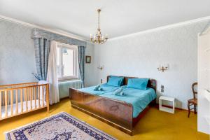 a bedroom with a bed and a crib at Gîte du forgeron - 6 à 8 personnes - Centre Alsace - Saint-Hippolyte in Saint-Hippolyte