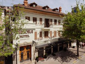 a large white building with a sign on it at Hotel Dimora 1927 in Tirana