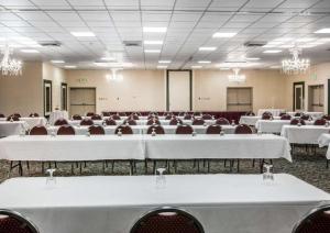 a banquet hall with white tables and chairs and chandeliers at Quality Inn & Suites Escanaba North in Escanaba