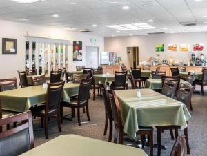 a dining room with green tables and chairs at Quality Inn & Suites Escanaba North in Escanaba