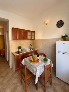 a kitchen with a table and a white refrigerator at Apartment Stegic 1 in Radovici