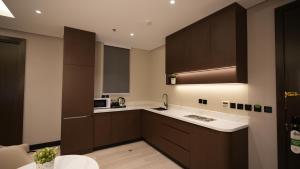a kitchen with brown cabinets and white counter tops at سنود النرجس Snood Al Narjis in Riyadh