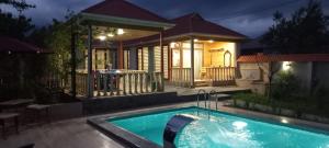 a swimming pool in front of a house at night at Mountain Hearth in Vǝndam
