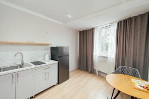 a kitchen with a black refrigerator and a table at Apart Hotel Anastasia in Chişinău +46 photos