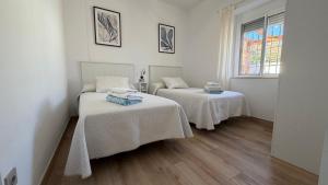 two beds in a room with white walls and wooden floors at Villa Delicia in Torrox +82 photos