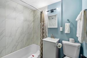a bathroom with a toilet and a sink and a tub at Broadway Inn in Council Bluffs