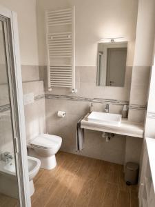 a bathroom with a sink and a toilet and a mirror at La Terrazza, comfort e relax tra i laghi in Borgomanero
