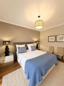 a bedroom with a large bed with a blue blanket at Casa do Piquinho in Ponta do Sol