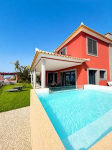 a house with a swimming pool in front of a house at Casa do Piquinho in Ponta do Sol