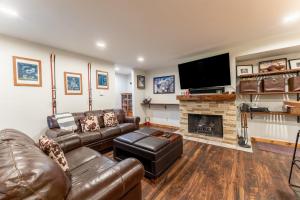 a living room with leather furniture and a flat screen tv at Wild Irishman #1030 in Keystone