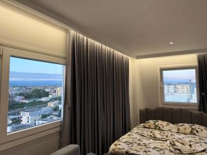 a bedroom with a bed and a large window at Eri Apartments in Durrës