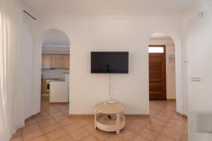 a living room with a tv on a white wall at V155 Villa Llebeig in Son Bou