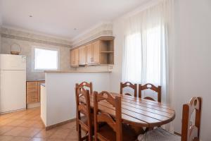 a kitchen with a wooden table and a refrigerator at V155 Villa Llebeig in Son Bou