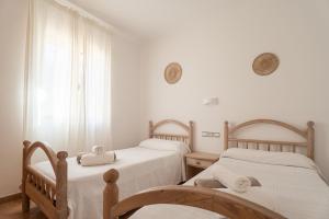 two beds in a room with white walls and a window at V155 Villa Llebeig in Son Bou +31 photos