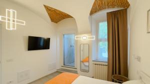 a bedroom with a bed and a tv on a wall at Belvedere 237A Lakeview Luxury Apartment in Ghiffa