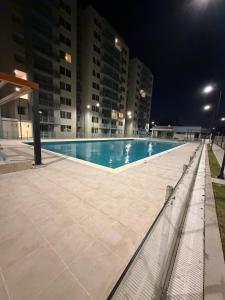 an empty swimming pool at night with tall buildings at Espectacular alojamiento in Gaira