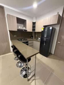 a kitchen with a counter and a black refrigerator at Espectacular alojamiento in Gaira