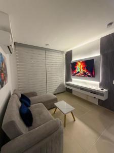 a living room with a couch and a tv at Espectacular alojamiento in Gaira