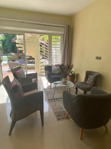 a living room with couches and chairs and a table at Le loft Acajou in Le Lamentin