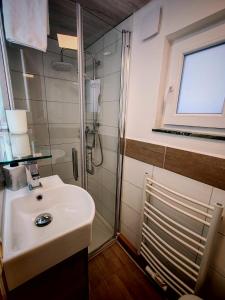 a bathroom with a sink and a shower at Ferienwohnung Berge & Seen in Hohenpeißenberg +23 photos