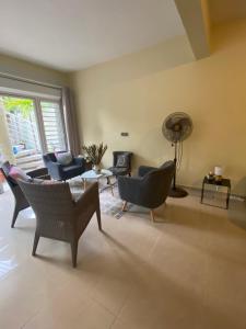 a living room with chairs and a table and a fan at Le loft Acajou in Le Lamentin