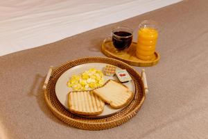 a plate of eggs and toast and a glass of orange juice at Hostal Los Cactus in Lima