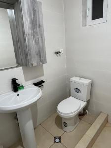 a white bathroom with a toilet and a sink at Leo Guesthouse in Dolasvip'i +34 photos