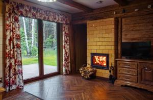 a living room with a fireplace and a tv at Podlaska Chatka Dziadka in Ciwoniuki