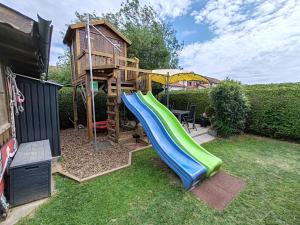 a playground with a slide and a tree house at Ferienwohnung Berge & Seen in Hohenpeißenberg