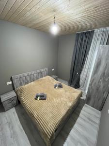 a bedroom with a bed with two shoes on it at Leo Guesthouse in Dolasvip'i
