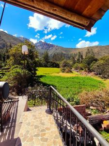 a balcony with a view of a field and mountains at Casa Rumiwillka in Urubamba