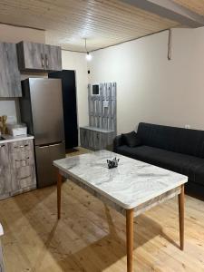 a living room with a table in front of a kitchen at Leo Guesthouse in Dolasvip'i