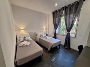 a room with two beds and a window at Vanity Suite in Cefalù