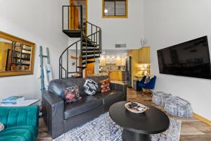 a living room with a black leather couch and a table at Summit House East #313 in Copper Mountain