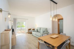 a dining room and living room with a table and chairs at Renovated Algarve Apartments with Pool in Armação de Pêra