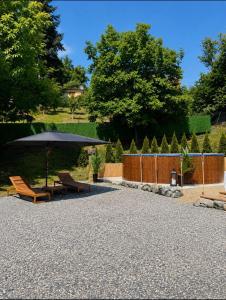 a patio with two chairs and an umbrella at De Papel Villa in Jankoviči