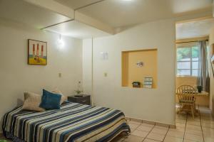 a bedroom with a bed with a striped blanket at Estudio #1 a 10 min del malecon in La Paz