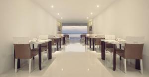 a dining room with tables and chairs and the ocean at Hush Lagoon 30 in Negombo