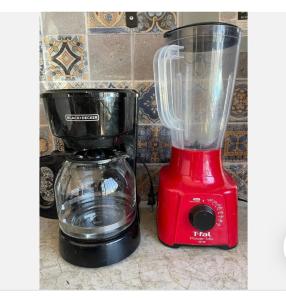 a red blender next to a coffee maker on a counter at Estudio #1 a 10 min del malecon in La Paz