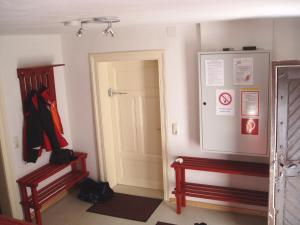a hallway with a red bench and a white door at Gruppenhaus Braz in Innerbraz