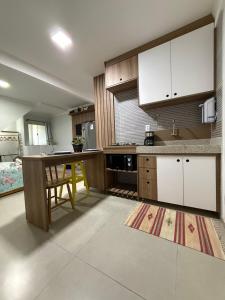 a kitchen with white cabinets and a table and a counter at Studio 25 Na Cidade do CAFÉ 300m do Centro in Brejetuba