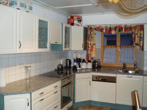 a kitchen with white cabinets and a sink at Gruppenhaus Braz in Innerbraz +28 photos
